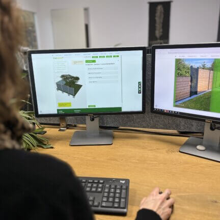Person plant einen sichtschutzzaun mit dem zaunplaner von mytimber. De auf zwei monitoren – 3d-zaunansicht und farbauswahl sichtbar