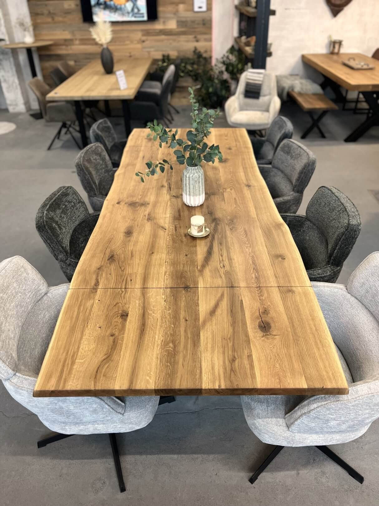 Massivholztisch mit ansteckplatten, ideal für flexibles wohnen, kombiniert mit modernen polsterstühlen.
