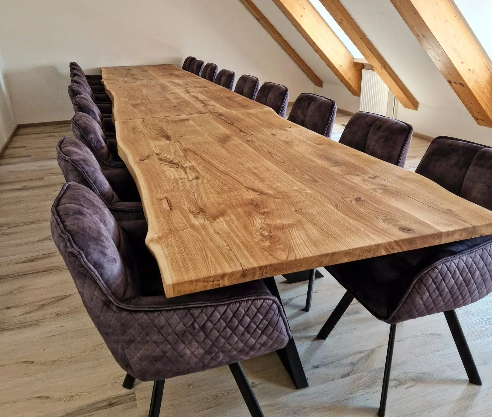Ein extra langer konferenztisch aus zwei tischplatten mit natürlich gewachsener baumkante und dazu passend der stuhl peter in anthrazit