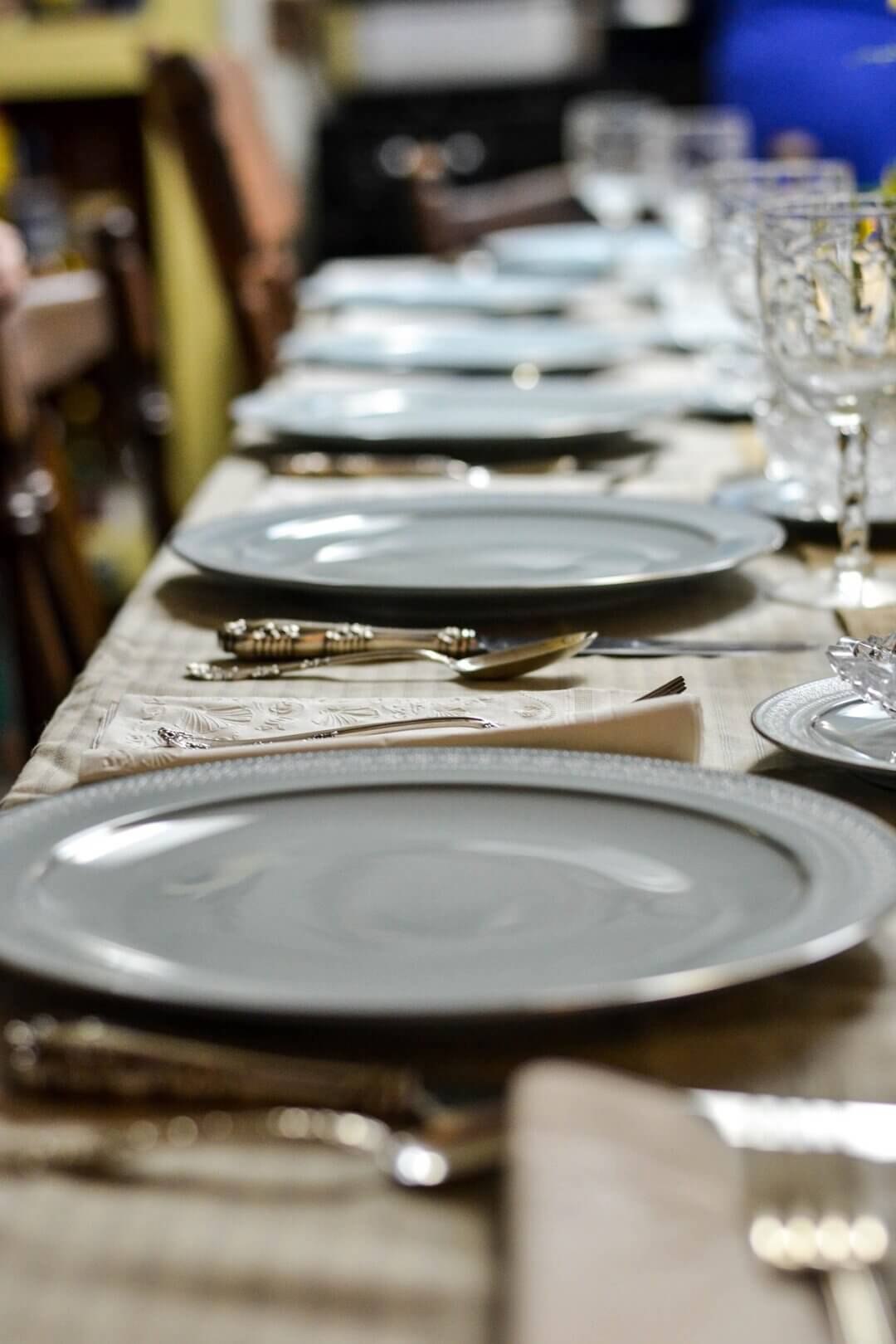Nahaufnahme einer gedeckten tafel auf einem tisch mit ansteckplatten, edles geschirr in elegantem arrangement