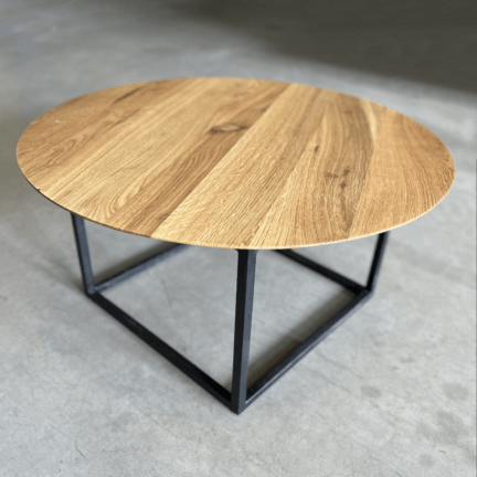 Runde tischplatte mit filigraner schweizer kante, geölter oberfläche und feinem cubegestell als couchtisch